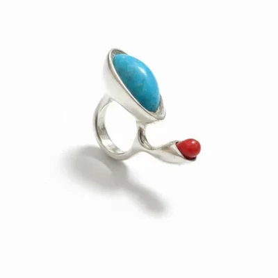 انگشتر نقره دست‌ساز با بدنه نامنظم و ارگانیک دارای یک سنگ اشکی آبی روشن و یک سنگ مستطیلی سبز زیتونی در پس‌زمینه سفید از زاویه دیگر